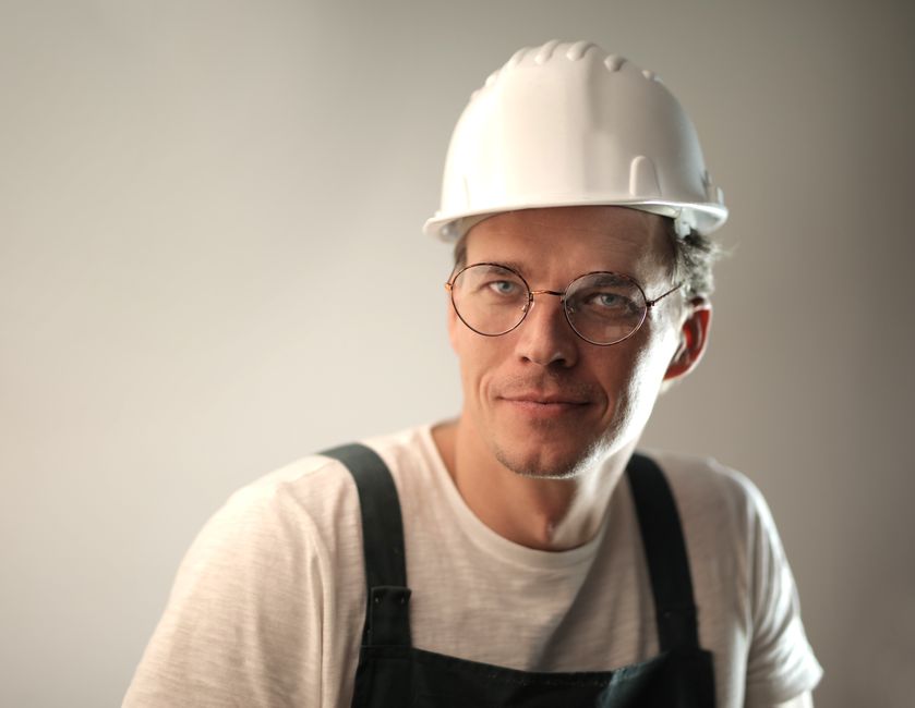 Friendly HVAC contractor smiling in front of a residential home