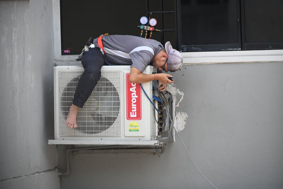 Professional HVAC technician performing air conditioner maintenance